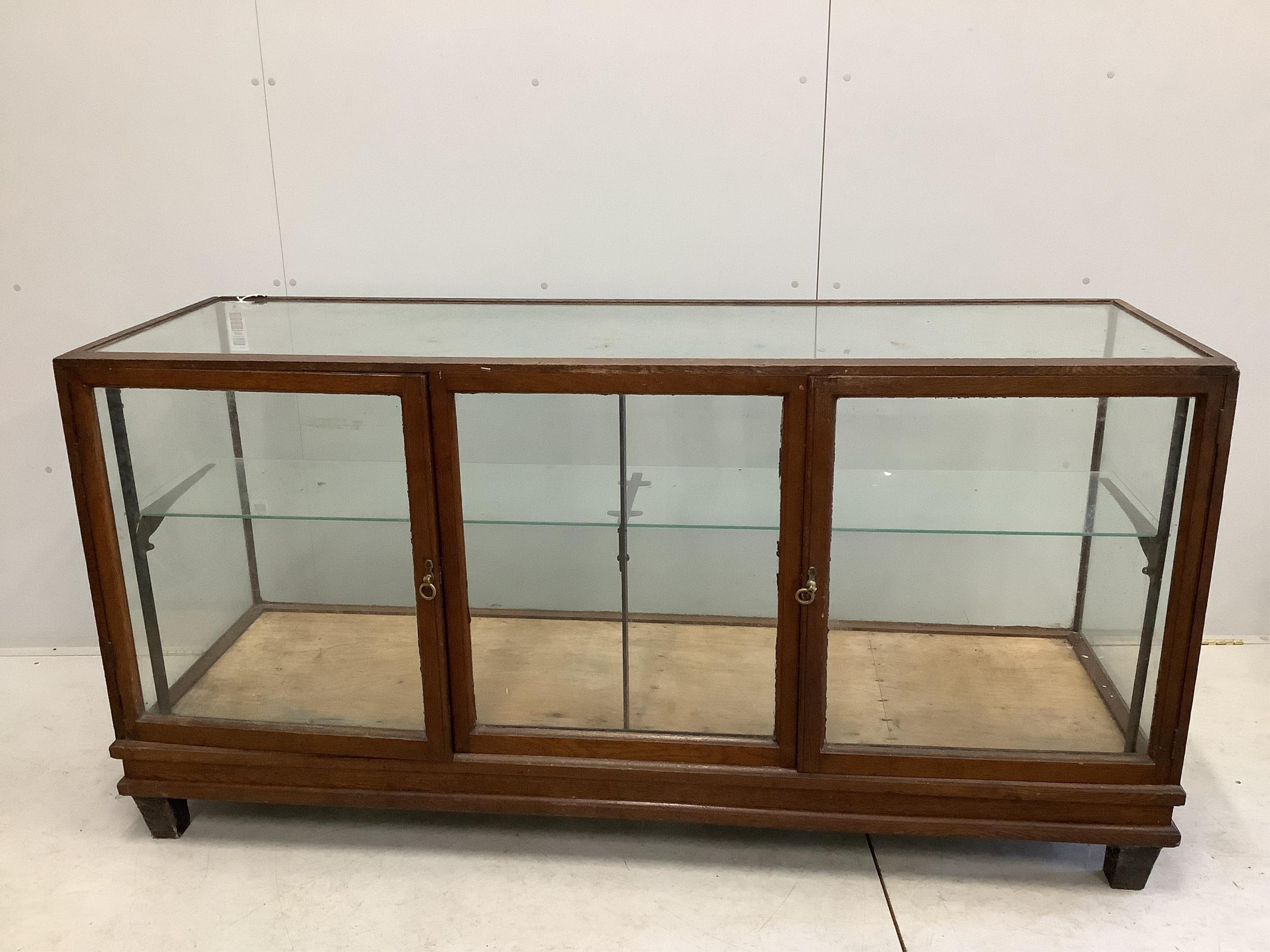 Pollard and Co., an early 20th century oak shop display counter cabinet, width 182cm, depth 59cm, height 91cm. Condition - poor to fair